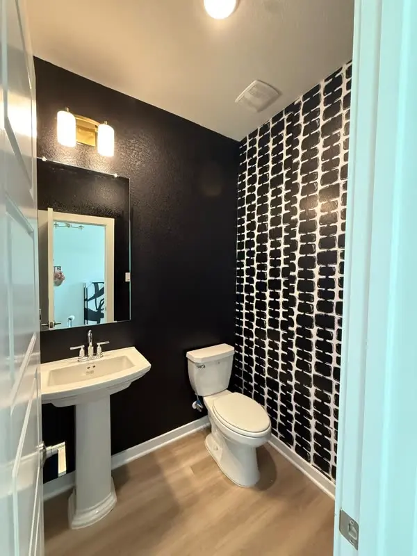 Powder room with textured black accent wall