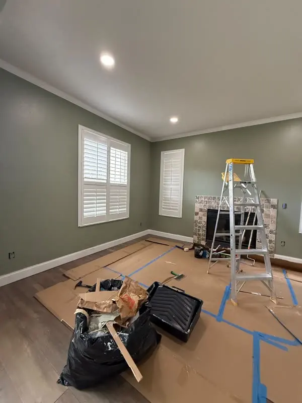Room prepped with drop cloths and taped edges during painting
